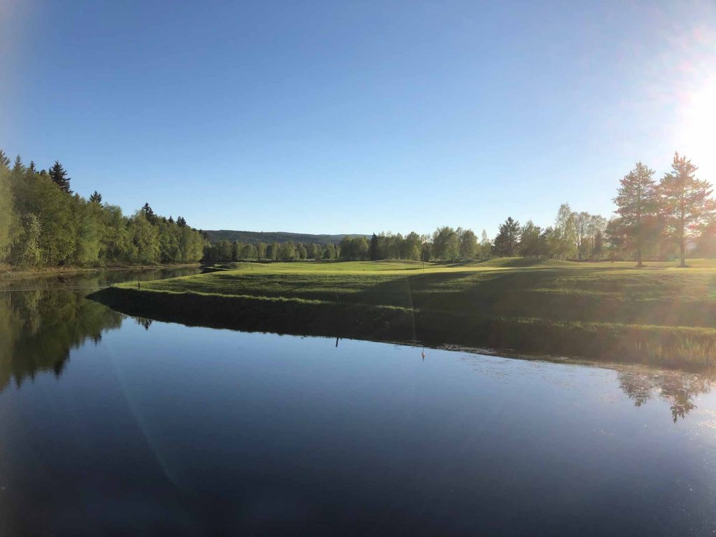 Solig bild på Hede -Vemdalens Golfbana vid ett vattendrag